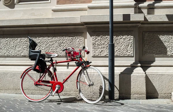 Red bike with basket on italian street. Typical italian architec