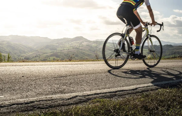 Yolda bisikletçi sporları. Güneş Işınları ve gölgeler üzerinde bisiklet — Stok fotoğraf
