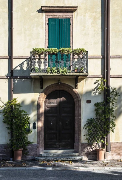 Fachada de casa de estilo italiano. Puerta y terraza con flores . — Foto de Stock