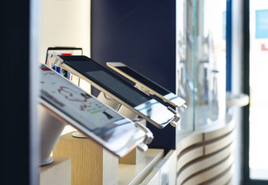 Telekomünikasyon dükkanındaki cep telefonları rafta. Işıklar Gsm üzerinde 