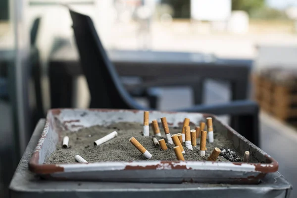 모래로 뒤덮인 재떨이와 묻은 담배. — 스톡 사진