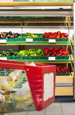 Sebze ile raf önünde süpermarkette Alışveriş sepeti.