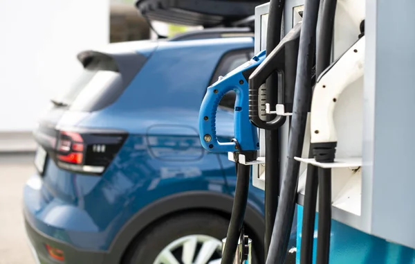 Elektrische auto op benzinestation. Blauwe auto en elektrische stekker voor char — Stockfoto