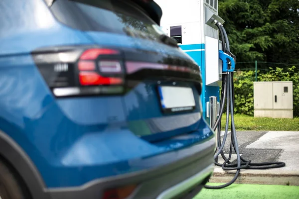 Electric car on gas station. Blue car and electric plug for char