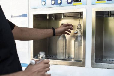 Sokağın ortasında maden suyu makinesi var. Öde ve içme suyu yükle