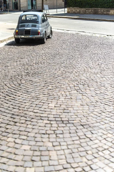 Vintage small car on traditional italian paved street. — Stock Photo, Image