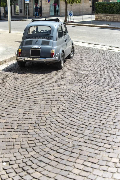 Винтажный маленький автомобиль на традиционной мощеной улице . — стоковое фото
