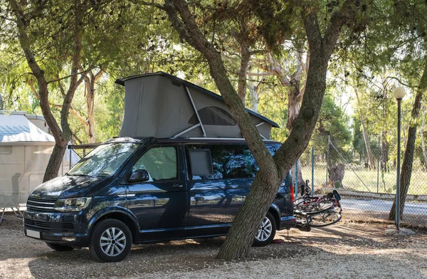 Blue Camper Caravan gelap di perkemahan. Pagi matahari . — Stok Foto