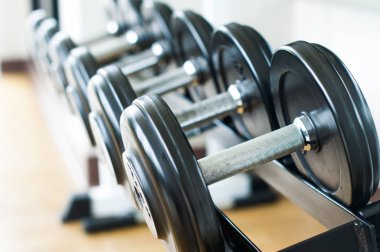 Arka planda bir spor salonunda egzersiz makineleri, yakın