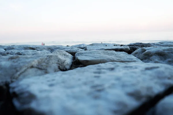 arka planda gri parke taşları, bulanık deniz suyu yakın 