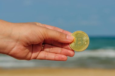 Genç kadının fiziksel bit sikke beach, bit sikke kavramı, e-ticaret ile el