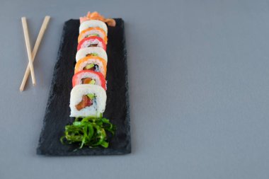 tabak çanak, Philadelphia rulo suşi somon, karides, avokado, krem peynir ile üzerinde suşi rulo. Sushi Menüsü. Japon yemekleri