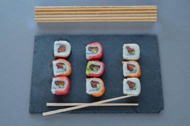 tabak çanak, Philadelphia rulo suşi somon, karides, avokado, krem peynir ile üzerinde suşi rulo. Sushi Menüsü. Japon yemekleri