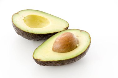 Olgun organik avokado yarısı beyaz arka planda tohum ile.