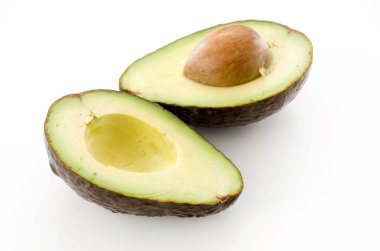 Olgun organik avokado yarısı beyaz arka planda tohum ile.