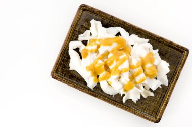 Beyaz arka planda kaynamış mürekkep balığı tabağında sirkeli miso.