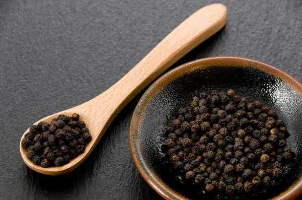 Zwarte Peper Zwarte Schaal Met Houten Lepel Zwarte Stenen Plaat — Stockfoto