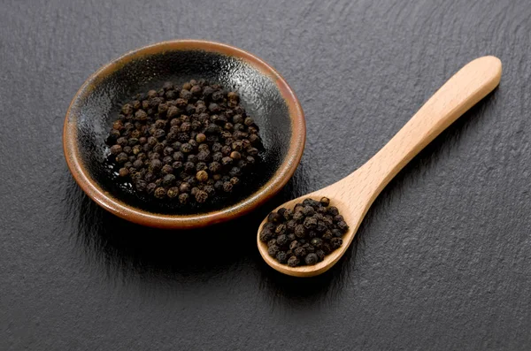 Black Pepper Black Dish Wooden Spoon Black Stone Plate — Stock Photo, Image