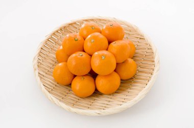 Olgun Citrus unshiu, satsuma, beyaz arka planda bambu süzgecinde portakal rengi TV.