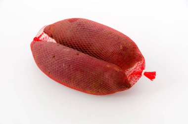 Beyaz arka planda bir poşette çiğ Japon tatlı patatesleri.