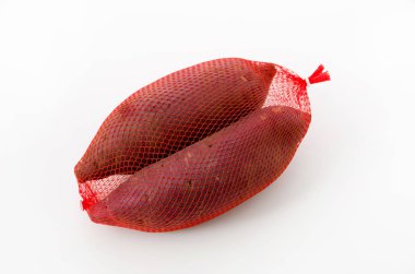 Beyaz arka planda bir poşette çiğ Japon tatlı patatesleri.