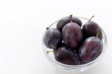 Yuvarlak kasede taze mor erikler