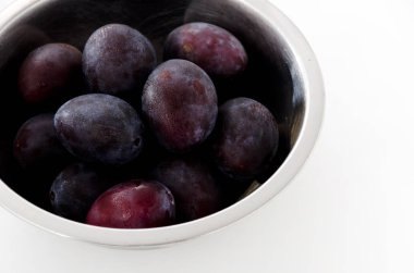 Paslanmaz çelik kasede taze mor erikler