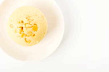 Beyaz arka planda mısır buğulamalı kek.