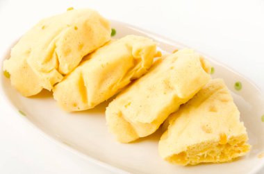 Beyaz arka planda mısır buğulamalı kek.