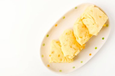 Beyaz arka planda mısır buğulamalı kek.