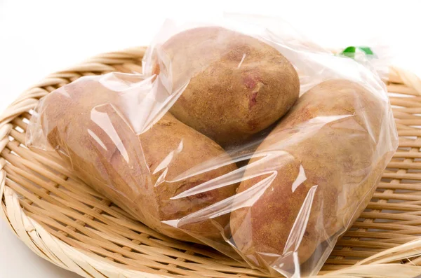 Fresh Red Skinned Potatoes Soil Plastic Bag Bamboo Colander White — Stock Photo, Image