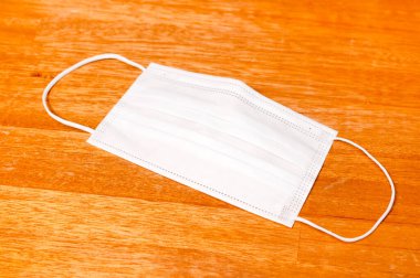 Ahşap masa arkasında tek kullanımlık yüz maskesi