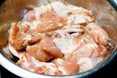 Paslanmaz çelik kasede marine edilmiş çiğ tavuk eti. 