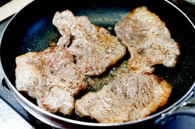 Kızarmış domuz etli biftek kızartma tavasında..