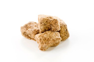 beyaz arkaplanda kahverengi şeker yığını.