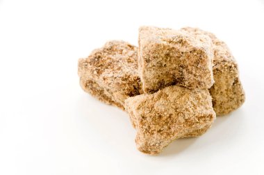 beyaz arkaplanda kahverengi şeker yığını.