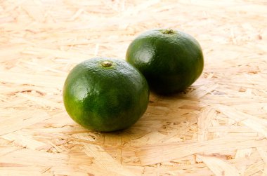 Citrus unshiu, mandarin satsuma portakalı kontrplak tahtasına izole edilmiş.