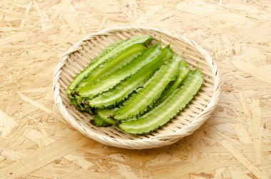 Tahta bir arka planda bambu elek üzerinde taze kanatlı fasulyeler.