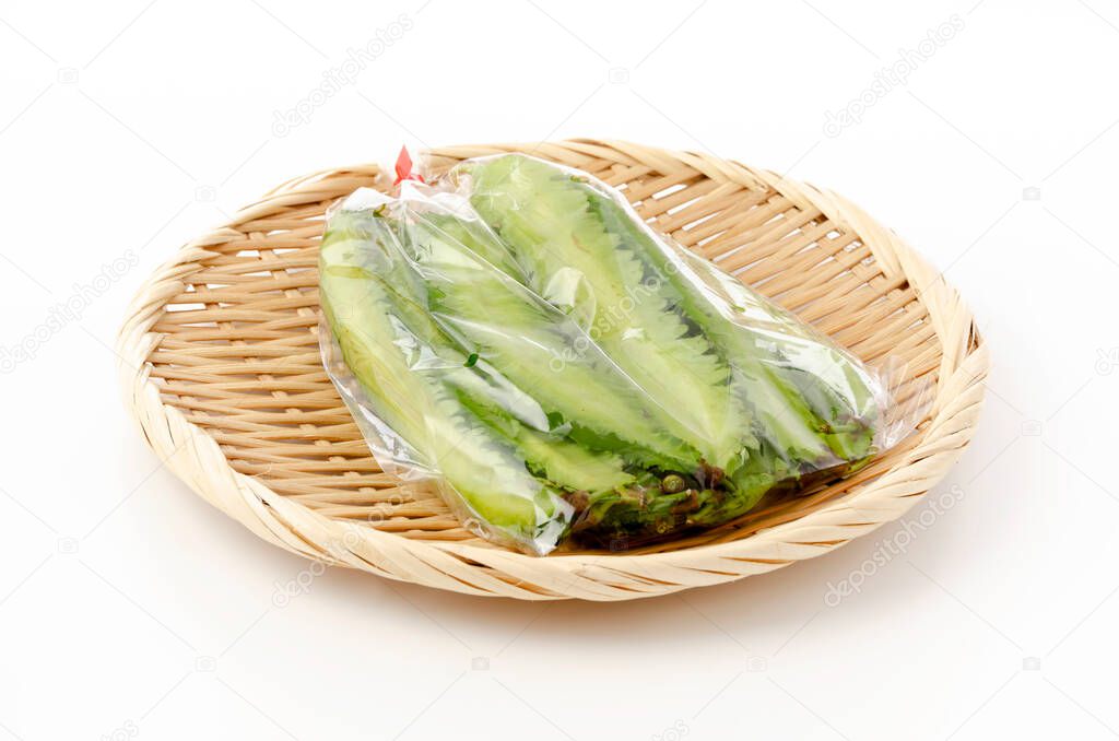 Fresh Winged beans  in plastic bag on a bamboo sieve on white background