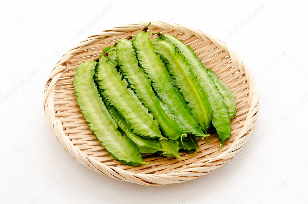 Fresh Winged beans on a bamboo sieve on a white background