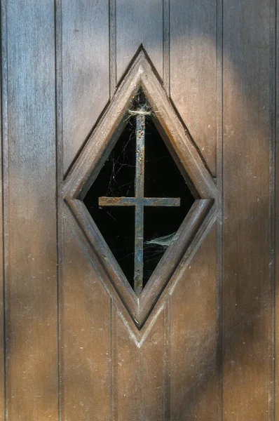 木门上有蜘蛛网和铁十字架的窗户 — 图库照片