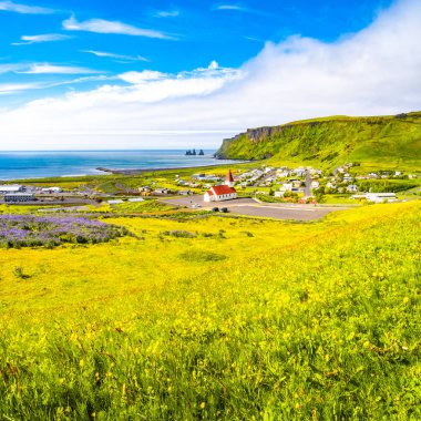 Bazalt görünümünü yığınlarının Reynisdrangar, siyah kum plaj, kilise ve şehir Vik, South Iceland, yaz saati