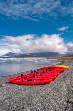 Buzul göl manzarası ile buzdağları ve kırmızı Kano içinde satır, Jokulsarlon, İzlanda