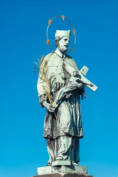 Estatua de santo con cruz en el Puente de Carlos de Praga en bl —  Fotos de Stock