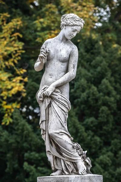 Estatua de sensual mujer desnuda renacentista griega con flores —  Fotos de Stock