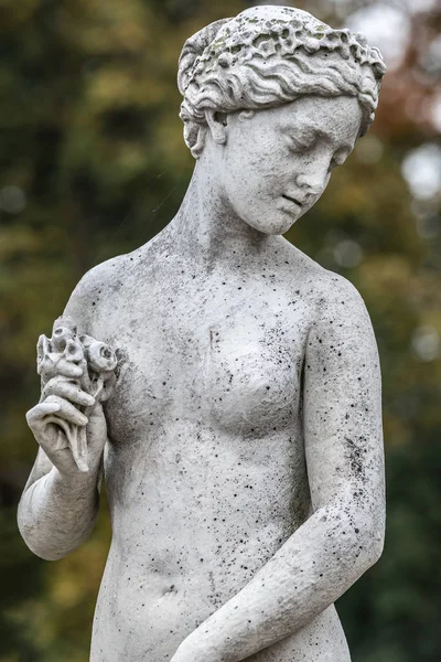Statue of sensual naked Greek renaissance era woman with flowers — Stock Photo, Image