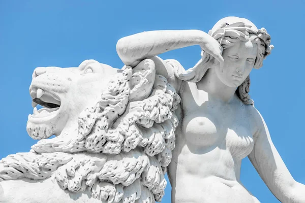 Ancient statue sensual renaissance era woman laying on big lion — Stock Photo, Image