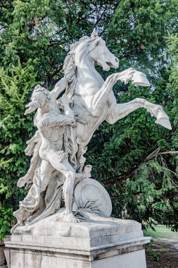 Genç yarı çıplak avcı heykeli bir at evcilleştirmek için çalışıyor, loc