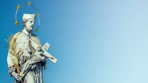 Estatua de santo con cruz en el Puente de Carlos de Praga en bl —  Fotos de Stock