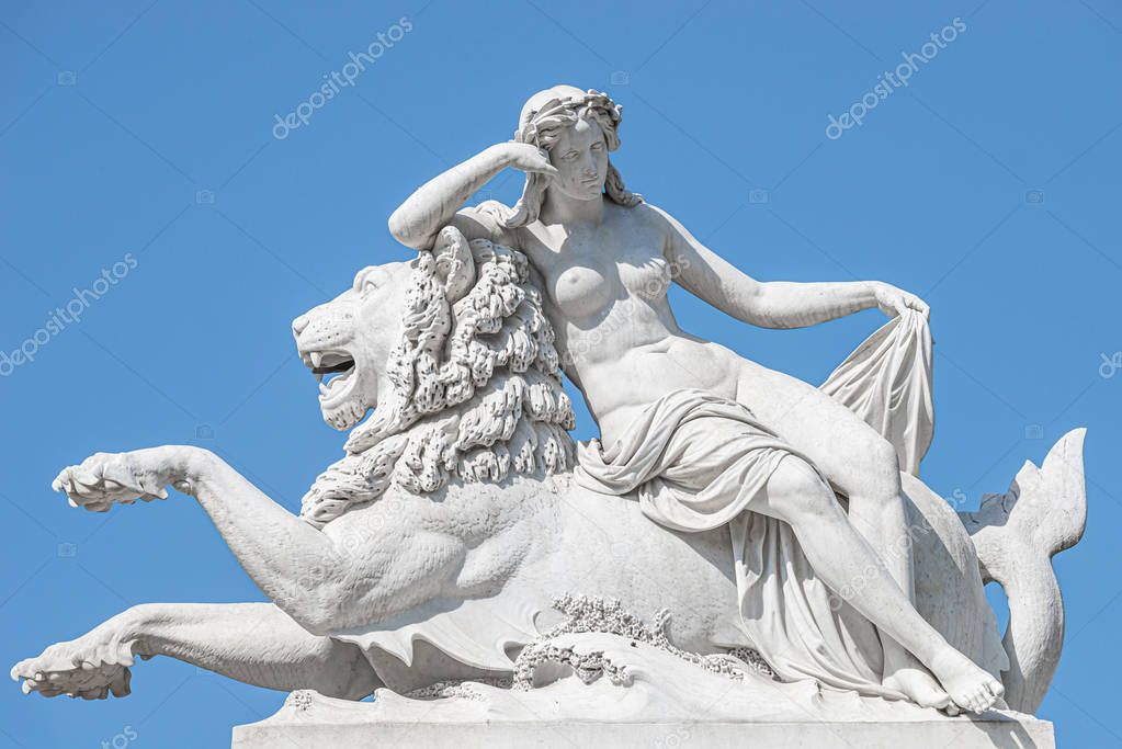 Old statue of sensual renaissance era woman laying on big lion a